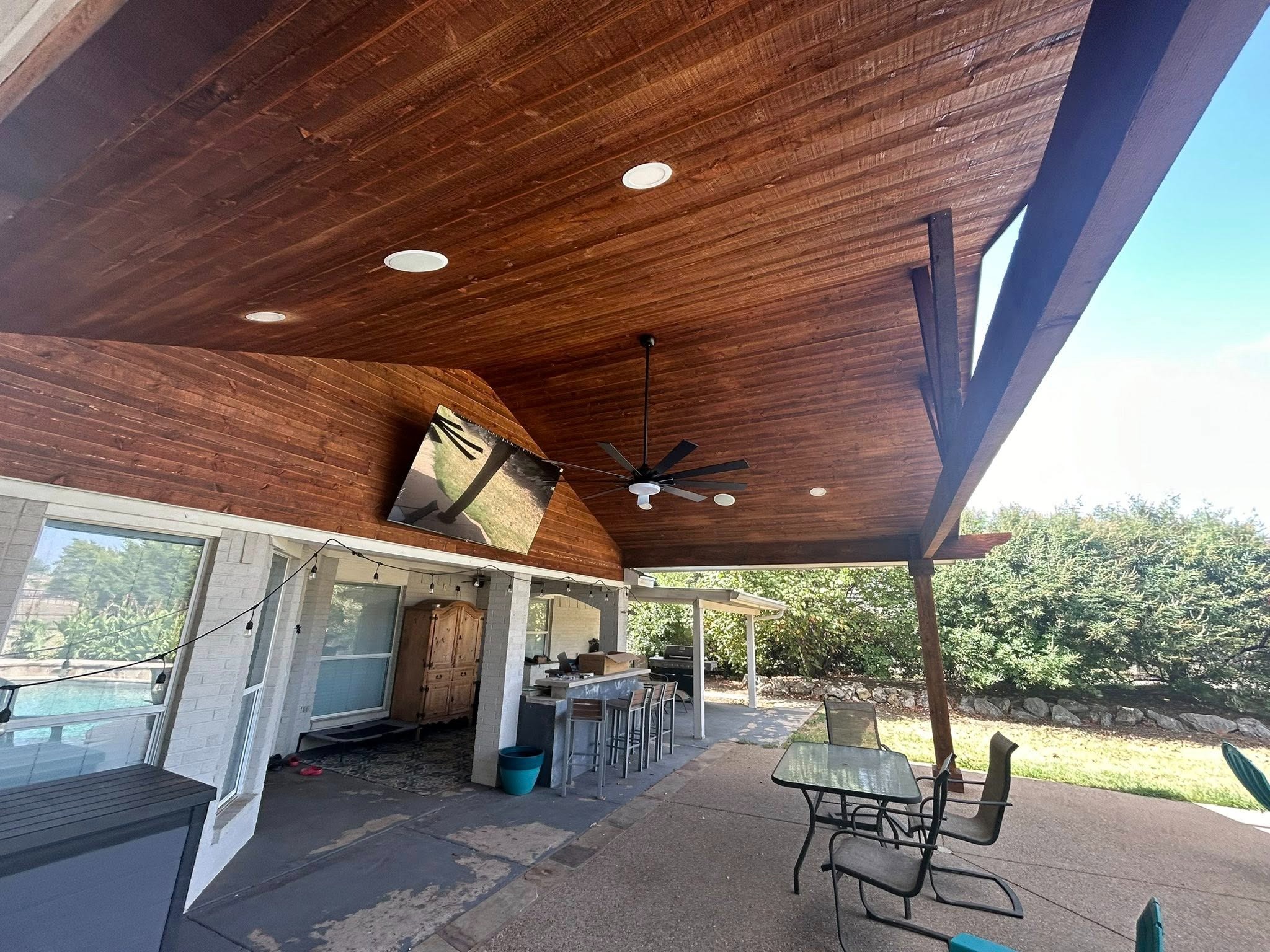 Poolside pavilion with stained ceiling, TV, and bar