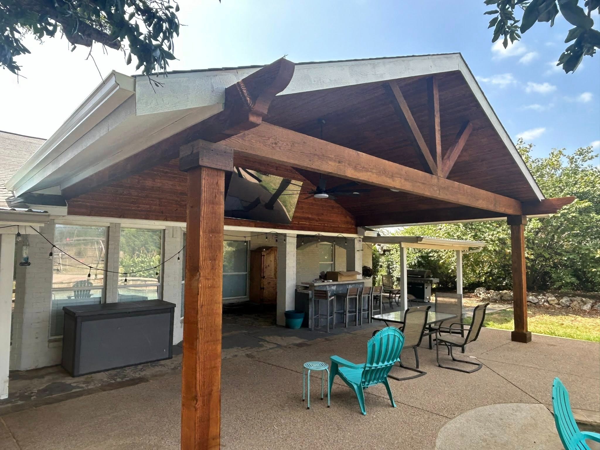 Stained exterior from side with teal chairs