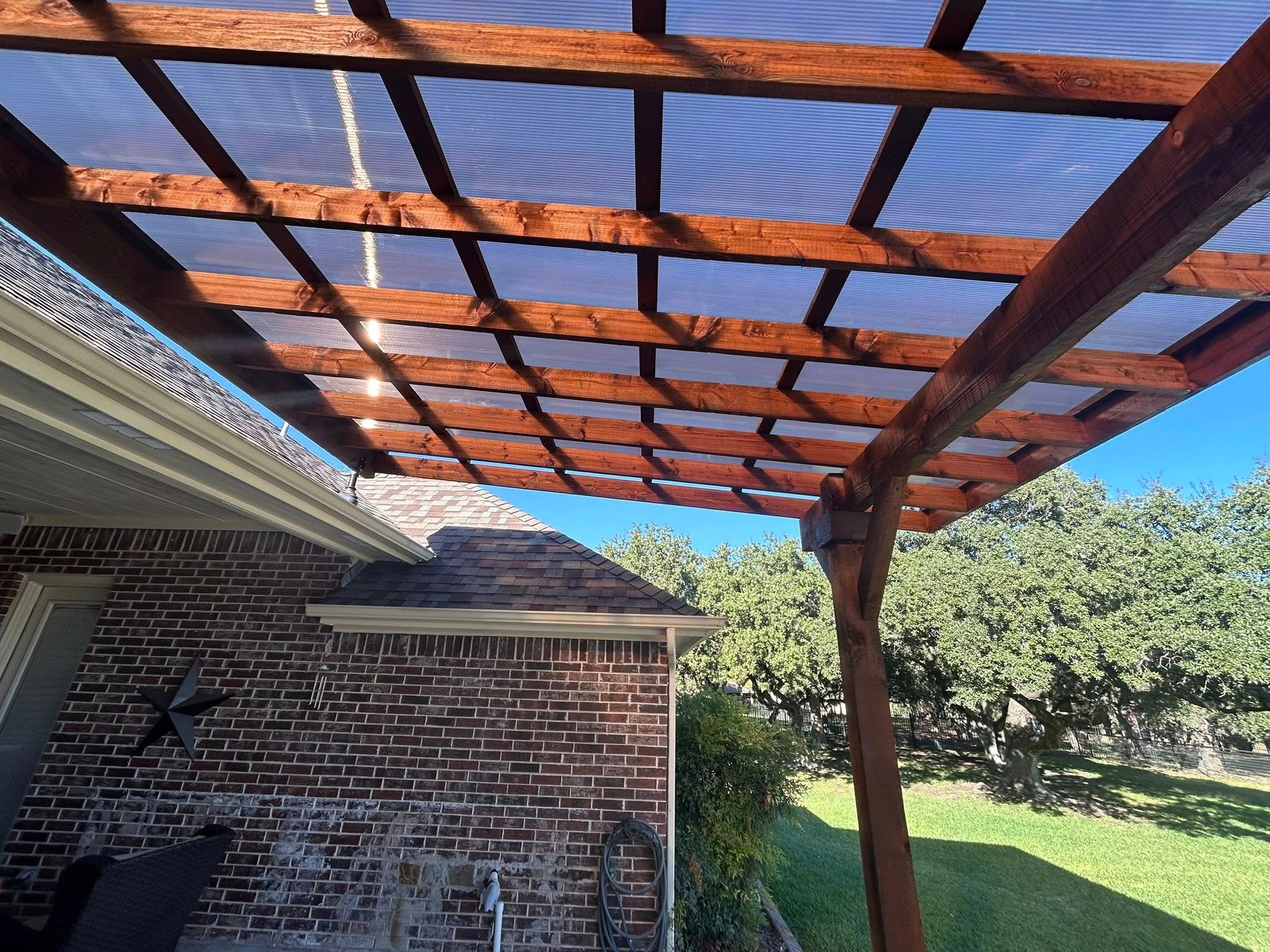 Under polycarbonate roof panels — stained cedar beams