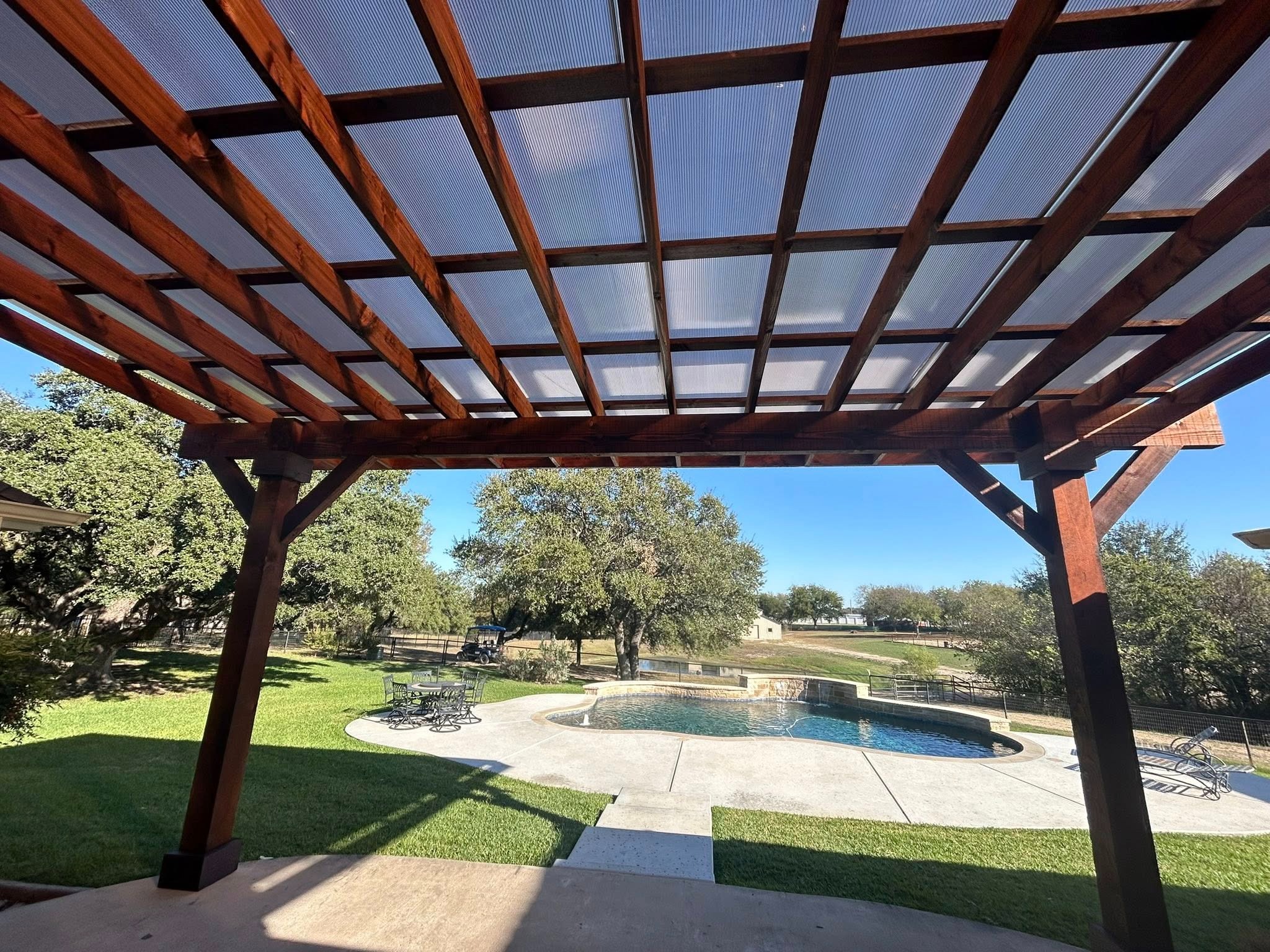 Under pergola looking at pool and spa