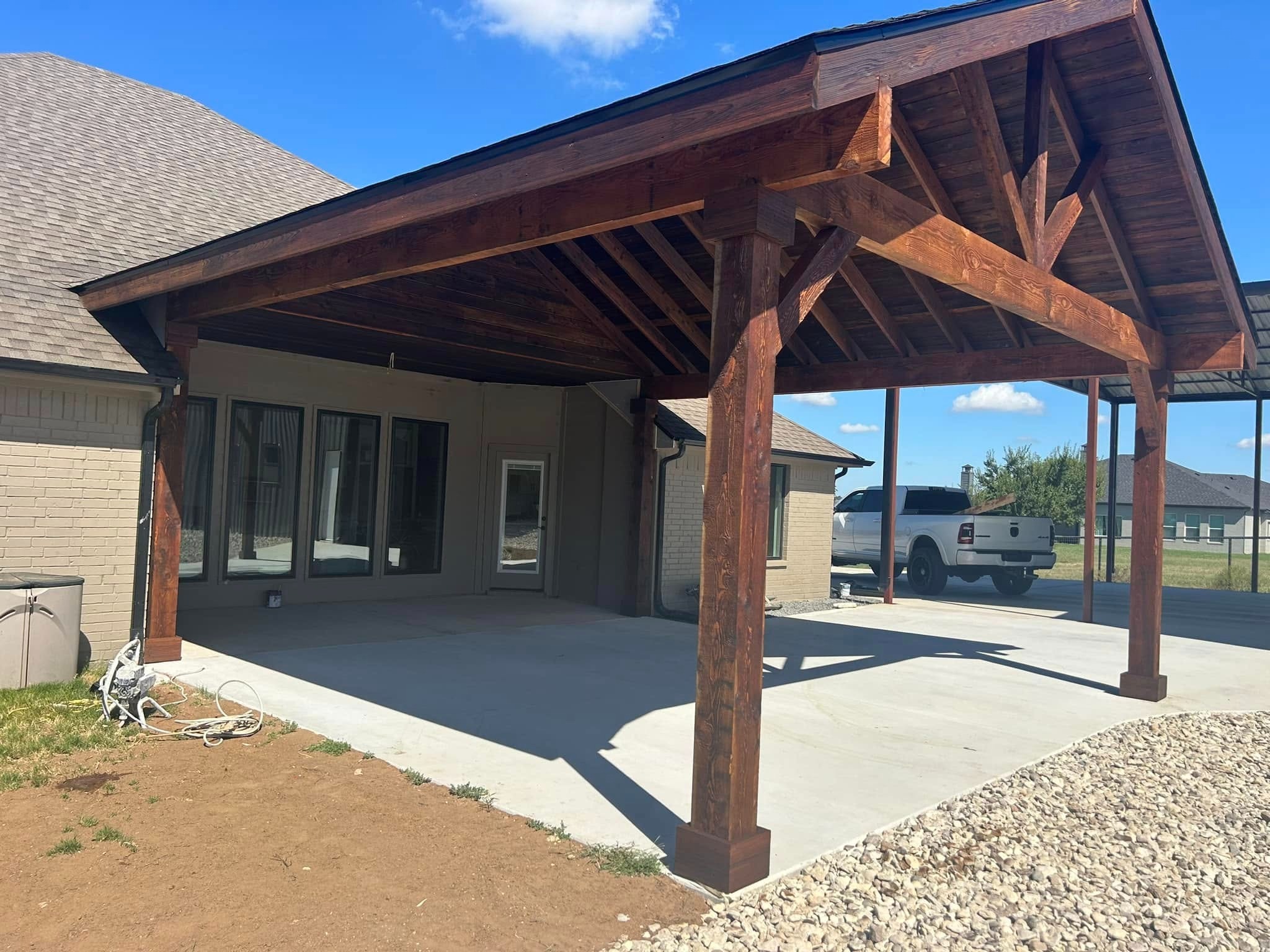 Finished stained gable patio cover on board-and-batten home