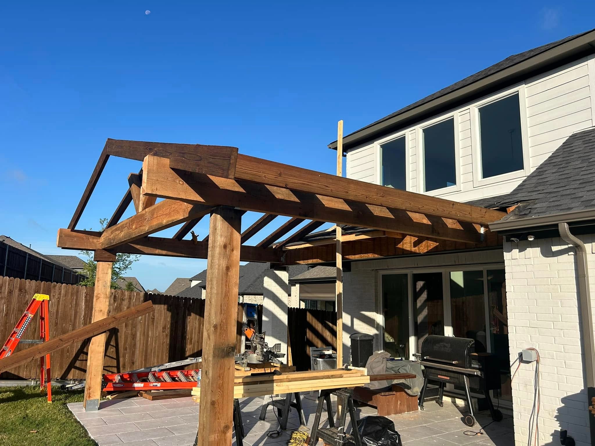 Pergola extension framing alongside gable cover